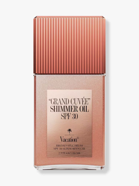 Rose gold bottle of Vacation Shimmer Oil SPF 30 Sunscreen on light gray background